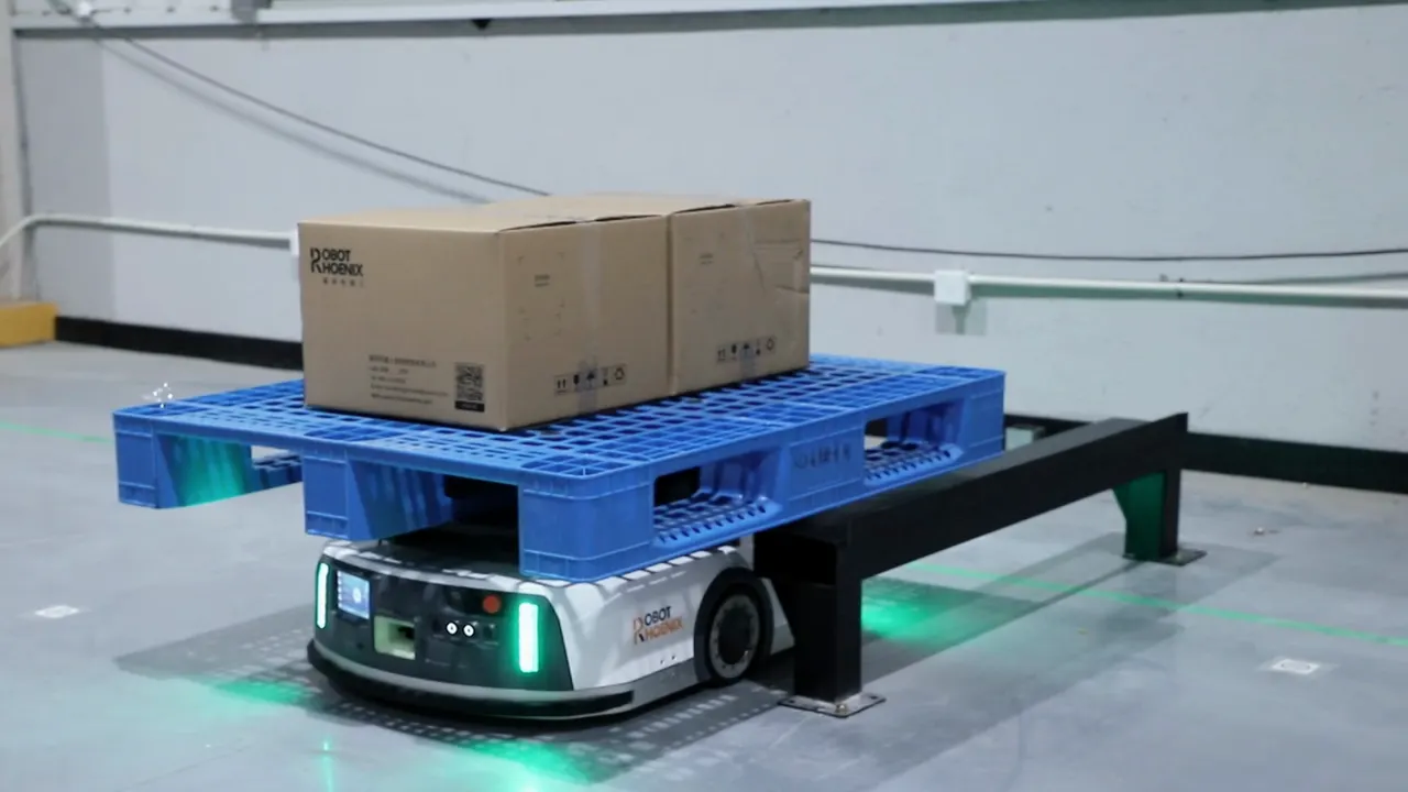 箱を載せたパレットを持ち上げ、搬送先の架台へ向かって走る潜り込み型AGV
