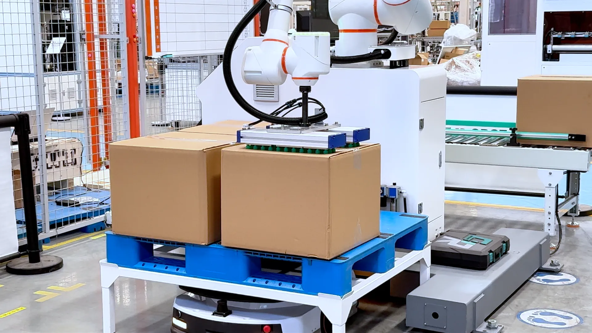 協働ロボットが段ボール箱をAGV上のパレットへ積み付けるパレタイジングロボット